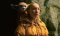 furry animal looks over shoulder of person wearing yellow
