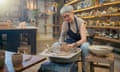 Senior artist woman making clay bowl on pottery wheel.