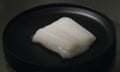 A white lump of what looks like chicken in a black petri-dish