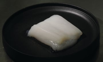 A white lump of what looks like chicken in a black petri-dish