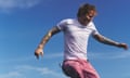 Ed Sheeran in white T-shirt and pink trousers against a blue sky