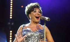 Bassey in silver sequin gown, singing at the mic, looking fabulous