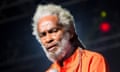 A black man with grey hair looks at the camera