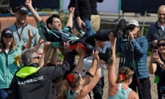 The Cambridge women’s Boat Race crew carry their cox, Jack Nicholas, aloft after their win