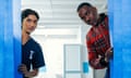 The Doctor and his companion peer behind some blue medical curtains