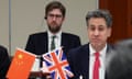 Britain's energy secretary Ed Miliband sits at a table with UK and China flags