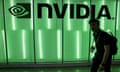 A man walks past an illuminated Nvidia logo