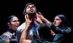 An Asian man looks up, flanked by two Asian women and a man; two of the people are reaching up to his face