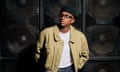 Sherelle dressed in black hat, glasses and jacket in front of a large soundsystem