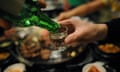 Honey Pig Korean Restaurant In Annandale, VA. ANNANDALE, VA - APRIL 8, At Honey Pig a customer pours a glass of Soju for his friend on April 8, 2011. Soju is the most popular alcoholic beverage in Korea. (Photo by Tracy A. Woodward/The Washington Post via Getty Images)