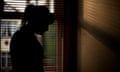 The silhouette of a woman standing by a window.
