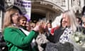 Women smile and raise glasses in front of the UK supreme court building