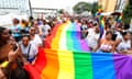 people carry a rainbow flag