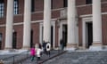 People walk up steps towards a door