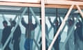 men with their hands up walking through an airport corridor