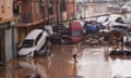 Residents look at cars piled up after being swept away by floods in Valencia, Spain.