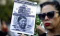 A woman holds a sign with a photograph of  a Mapuche woman with 'Where is Julia Chuñil' written above it in Spanish, among a crowd of people