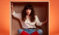 Bridget Christie photographed earlier this month. She is in a box, dressed as Kate Bush wearing a cream shirt, jeans with red knee-length socks over the top