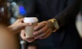 Barista serving coffee in a takeaway paper cup