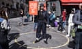 Street performer standing in a crowd with a placard